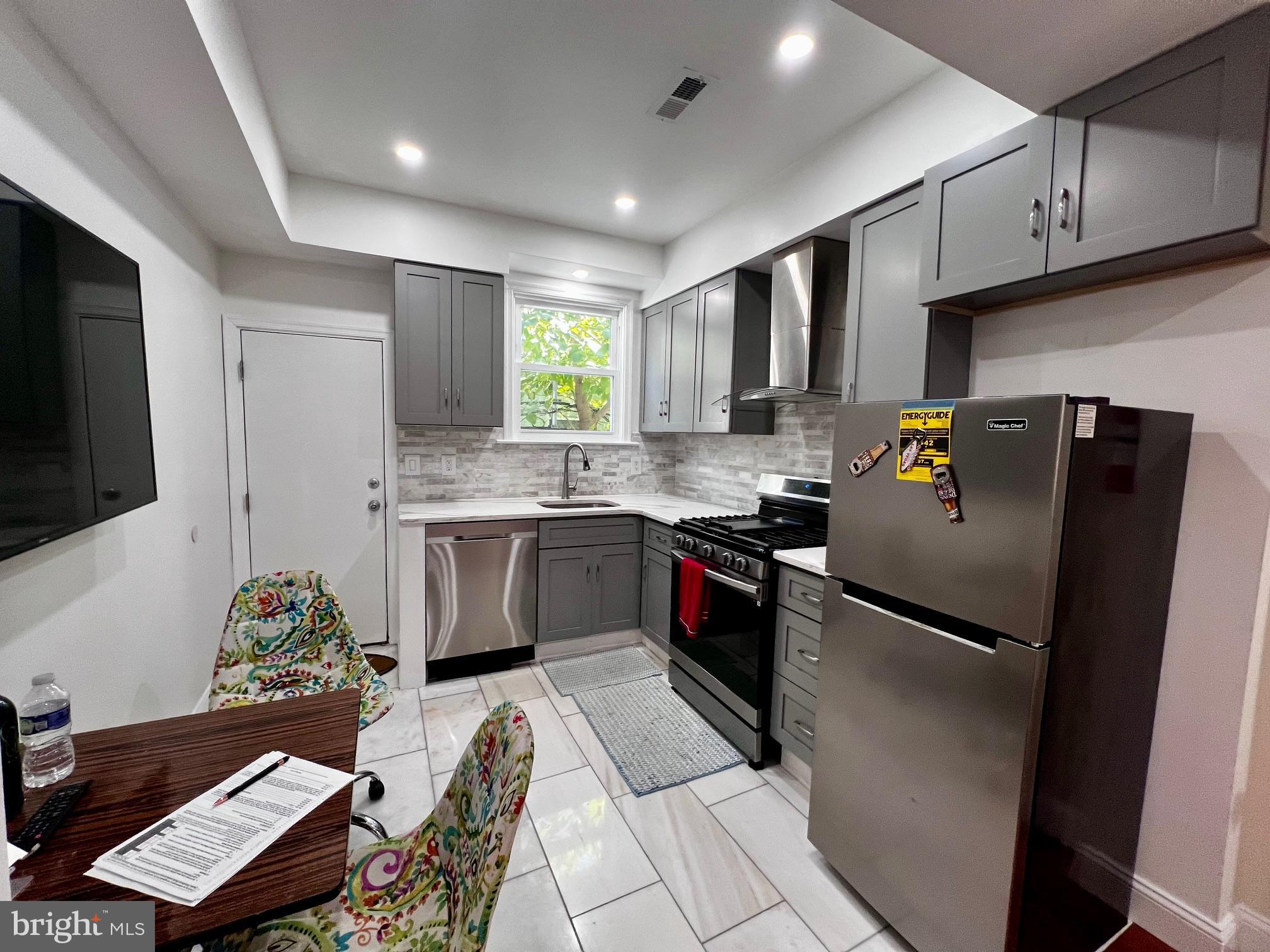 a kitchen with stainless steel appliances granite countertop a refrigerator sink and stove