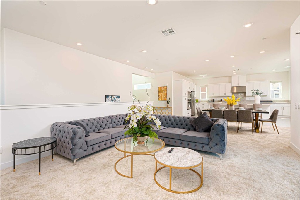 a living room with furniture kitchen view and a table