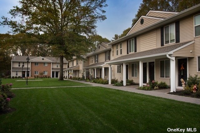 front view of a brick house with a yard