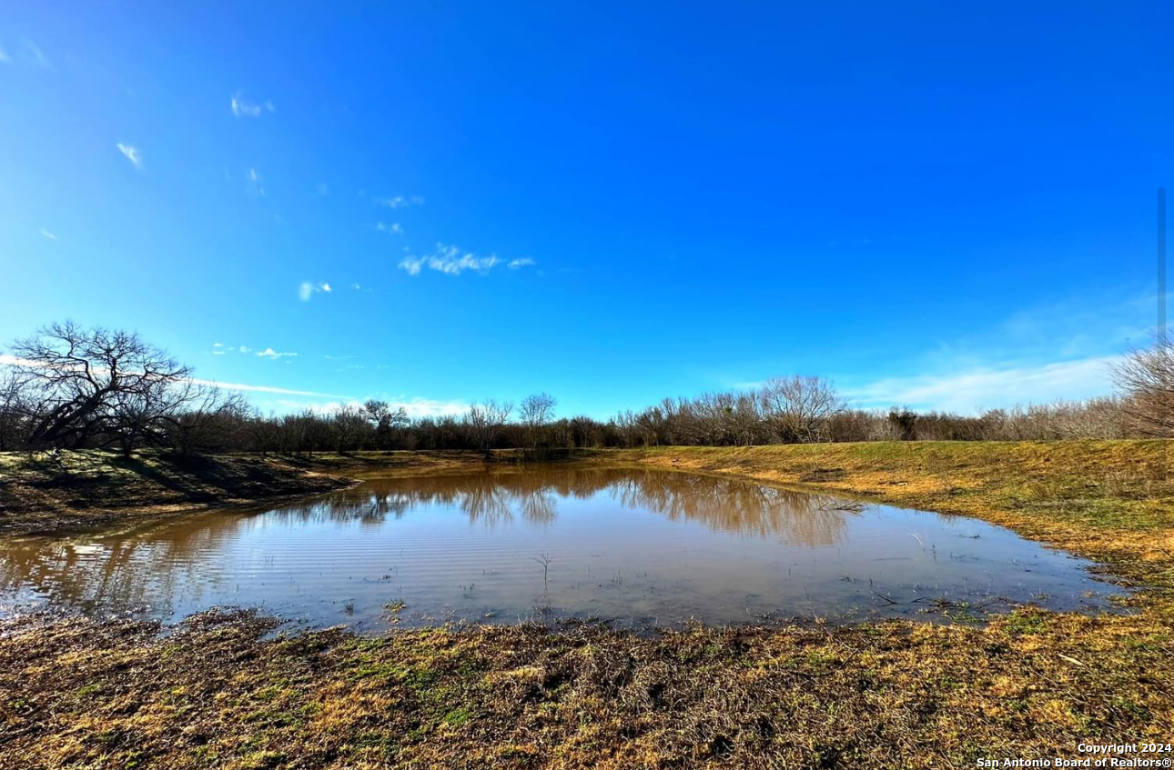 a view of a lake with lawn chairs and wooden floor