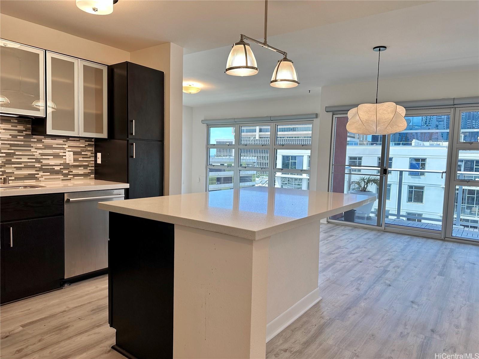 a kitchen with stainless steel appliances granite countertop a sink a stove and a wooden floors