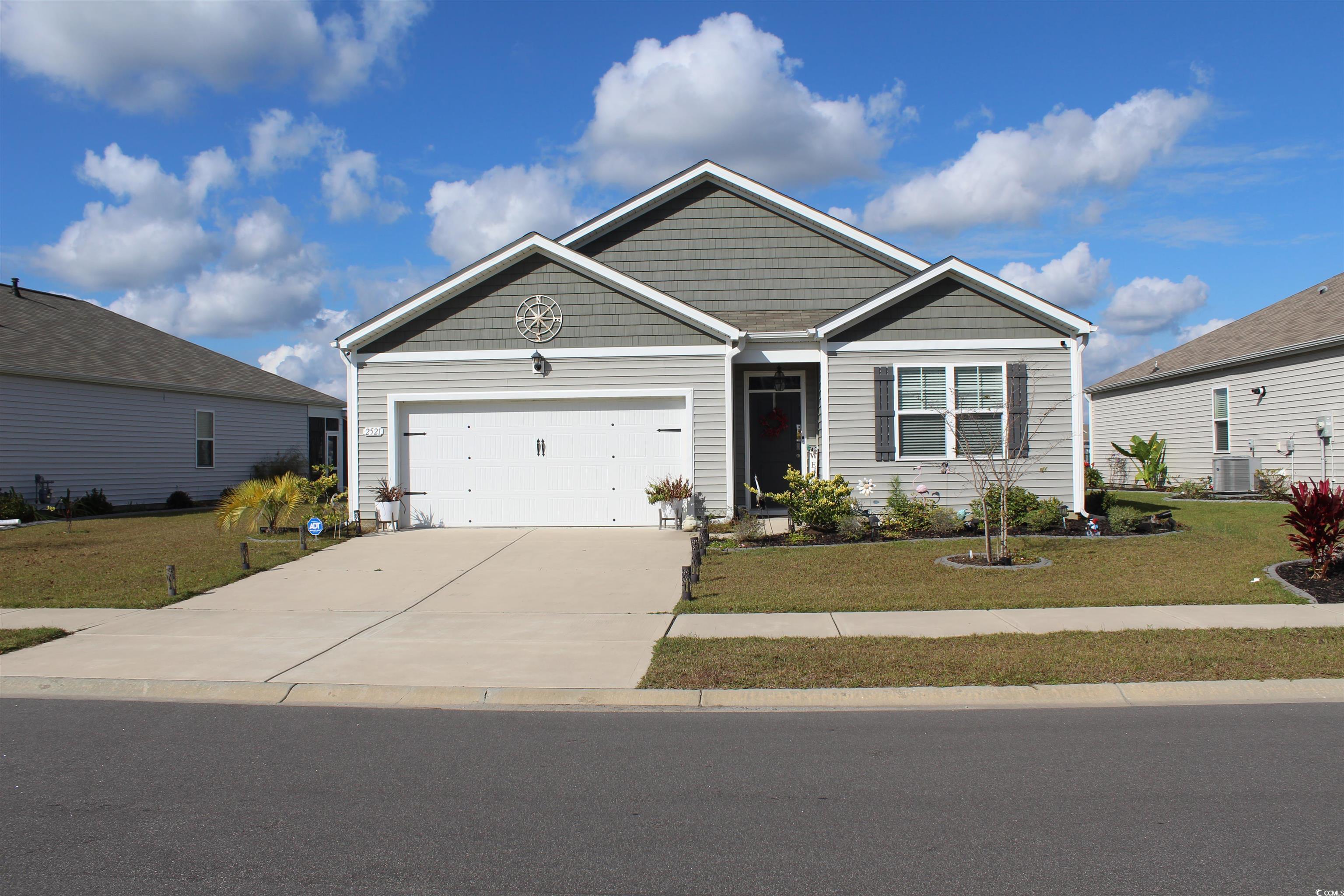 View of front facade with a front yard and a garag