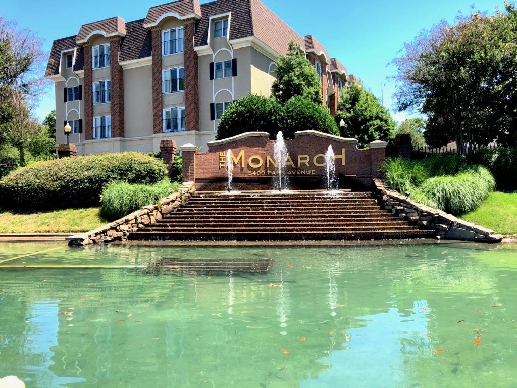 a view of a large pool with lawn chairs and a big yard