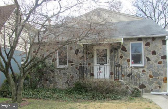 a view of a brick house with large windows and large tree