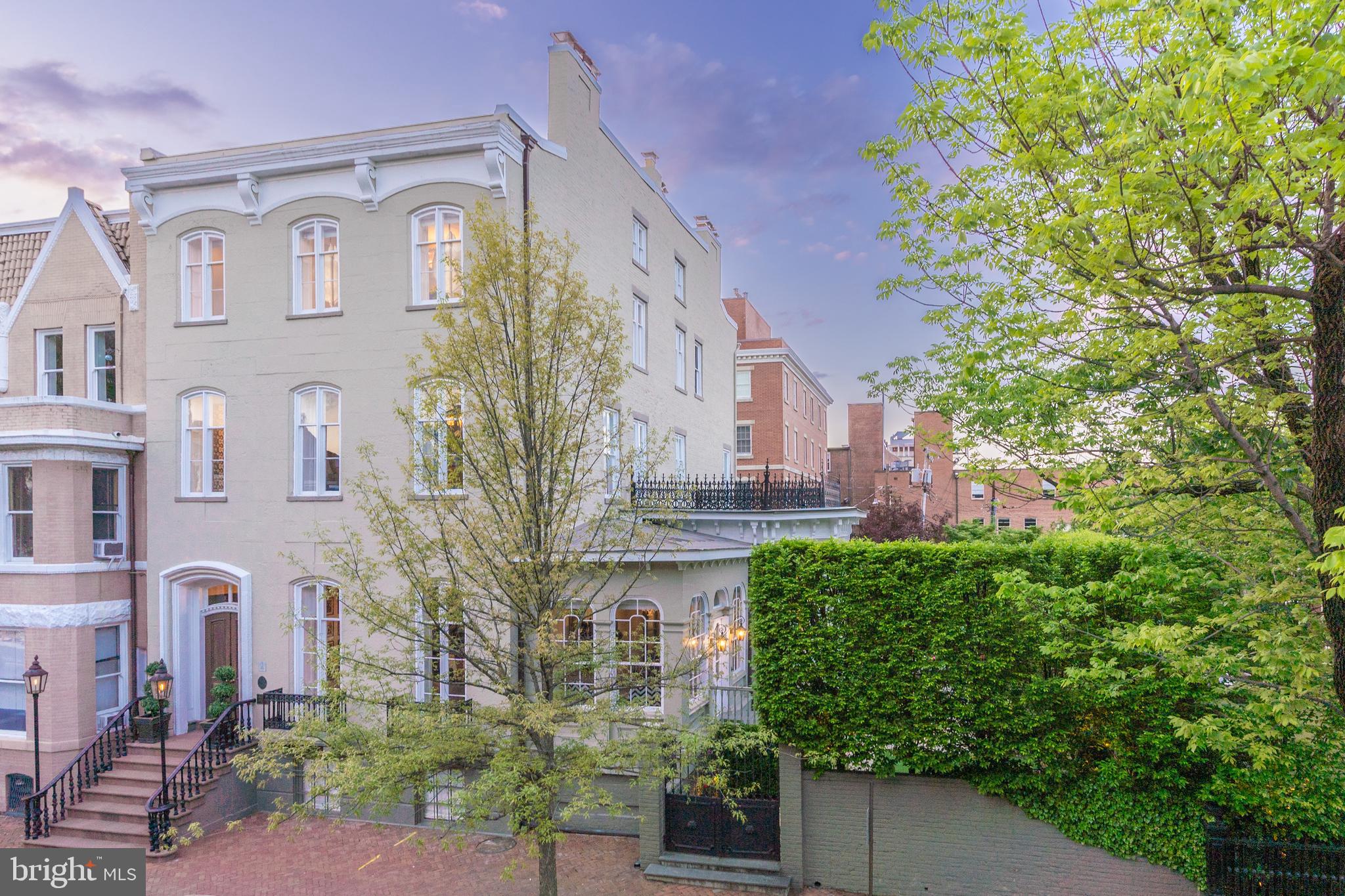 a front view of a multi story residential apartment building with a yard and outdoor seating