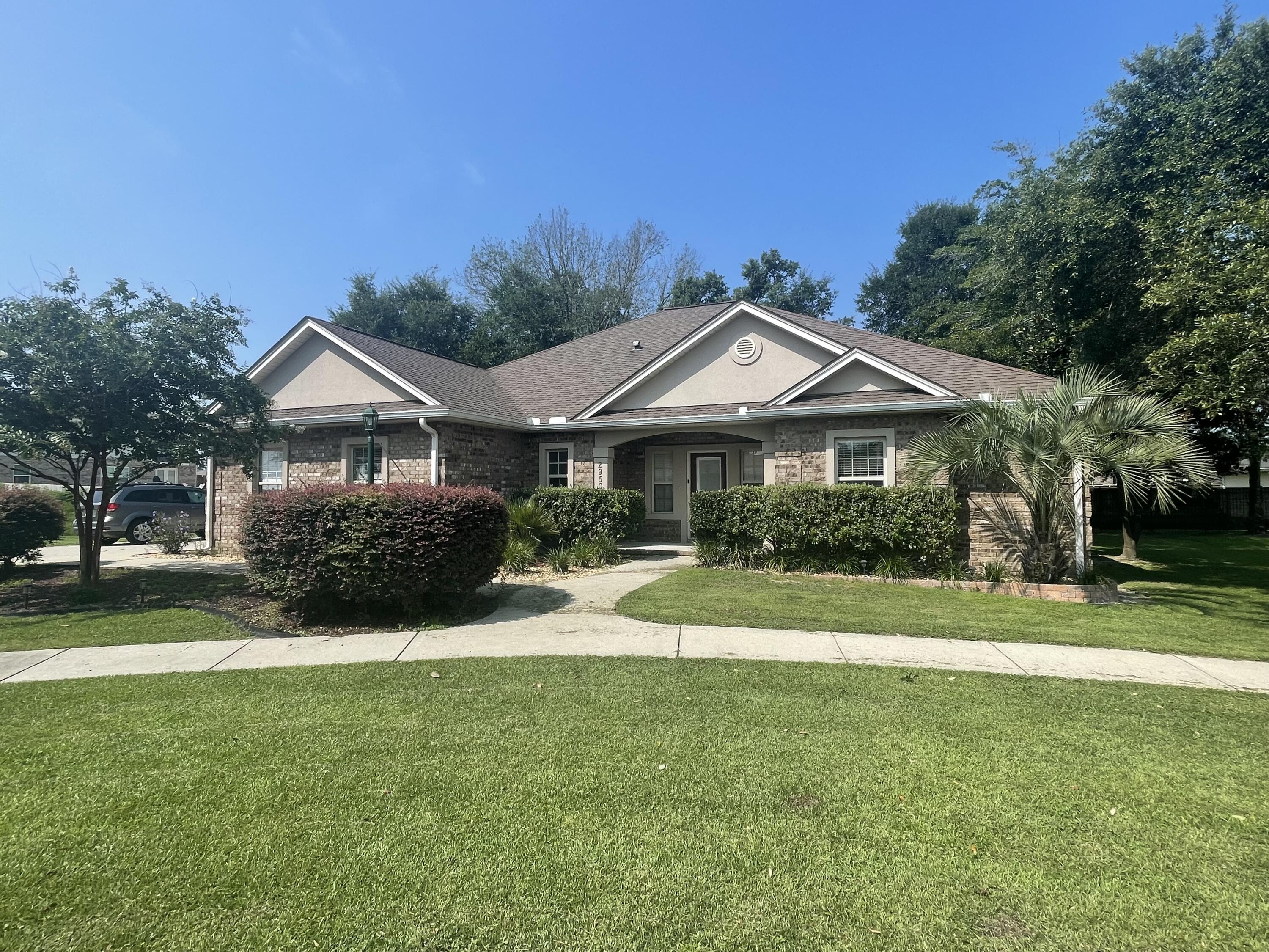 a front view of a house with a yard and trees