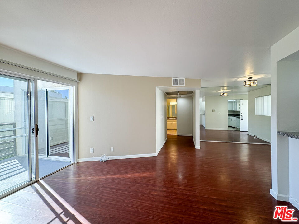 a view of empty room with wooden floor