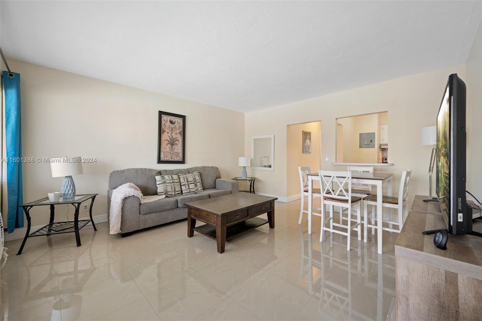 a living room with furniture a flat screen tv and a table