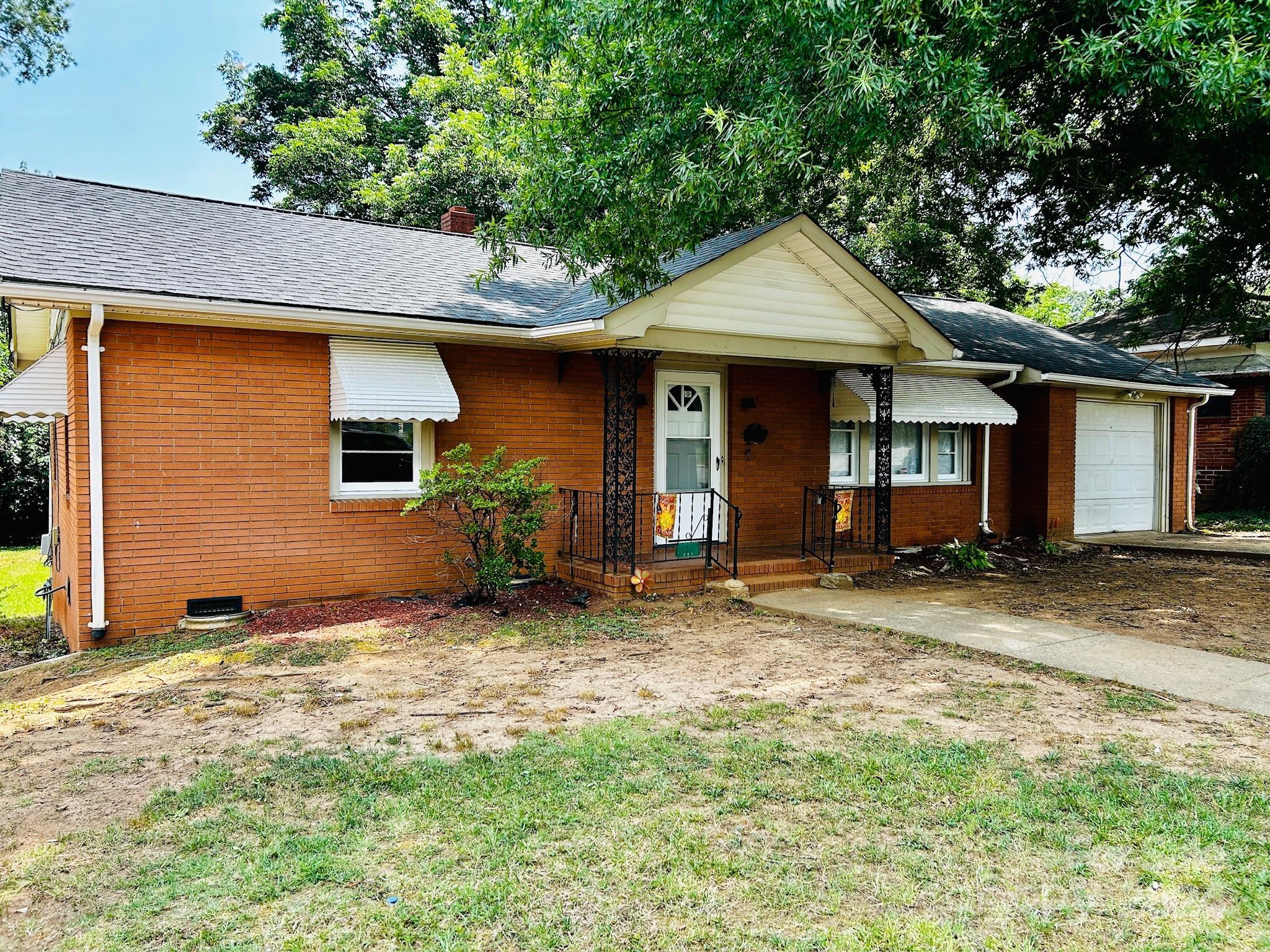 a view of a house with backyard and trees