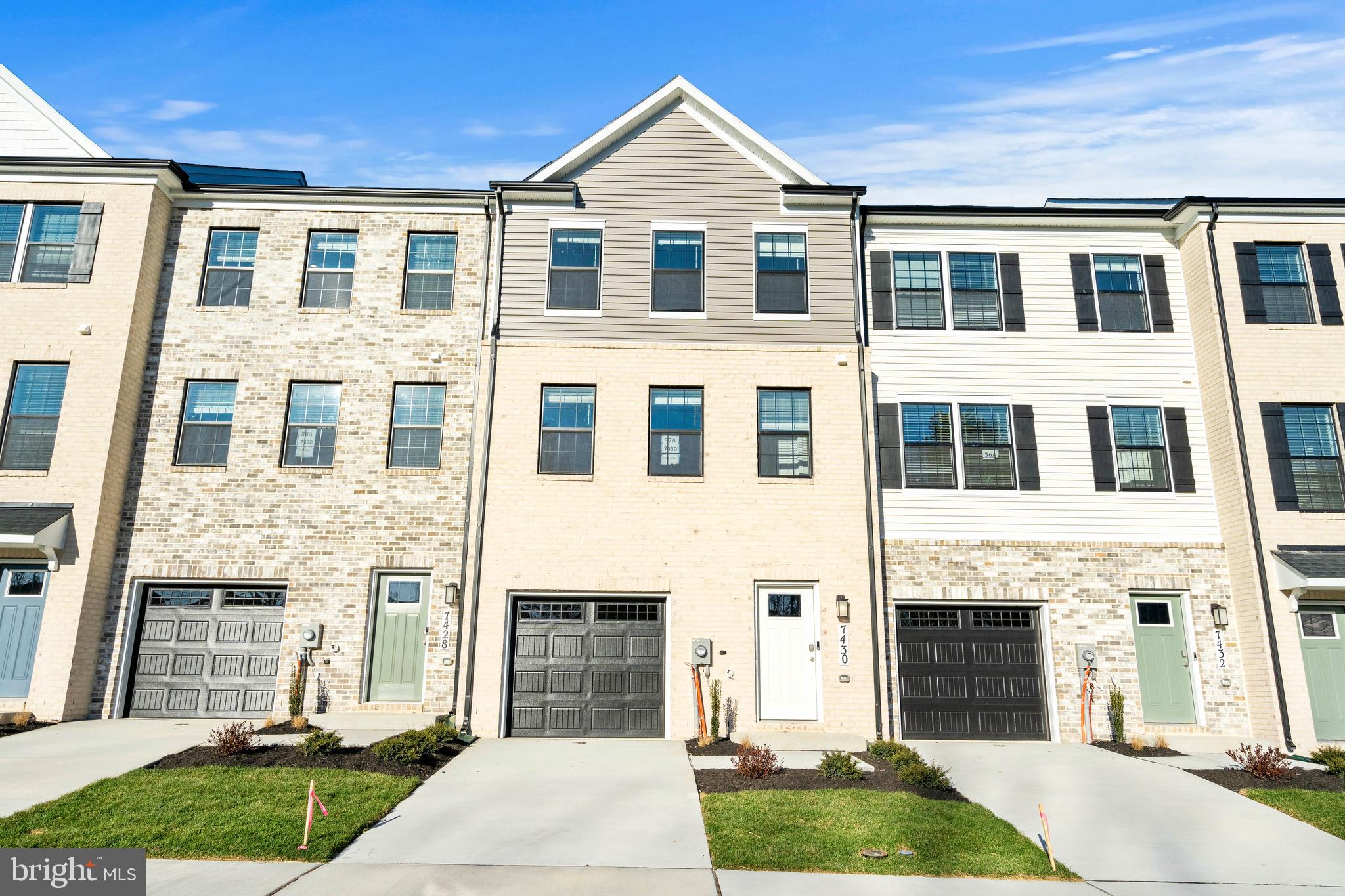 a front view of a house with yard and parking