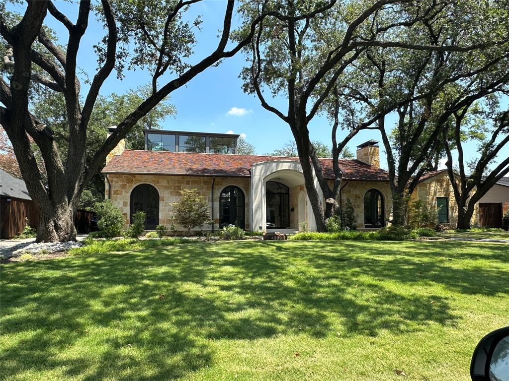 a large house with a big yard and large trees