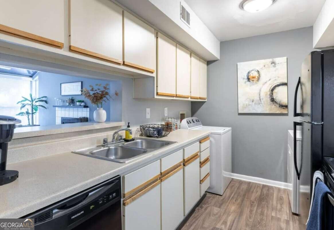 a kitchen with a sink appliances cabinets and a window