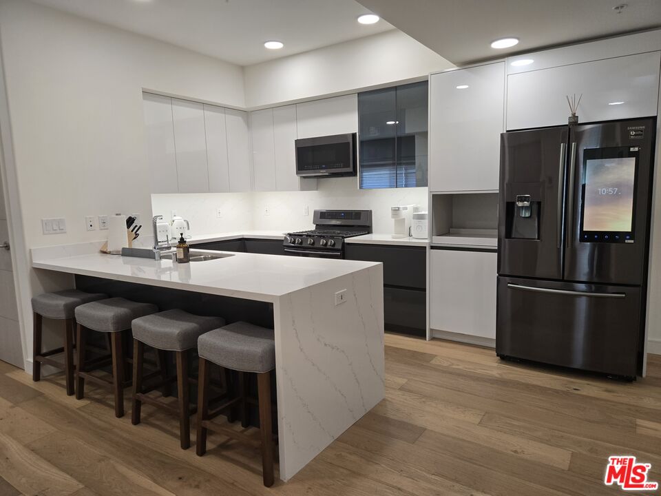 a kitchen with a sink stainless steel appliances and refrigerator