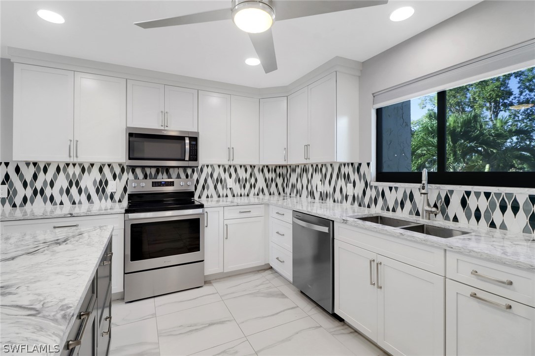 a kitchen with granite countertop white cabinets and white appliances