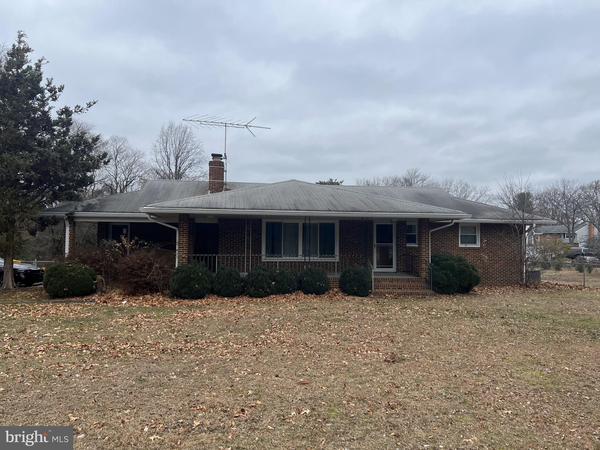 a front view of a house with a yard and potted plants