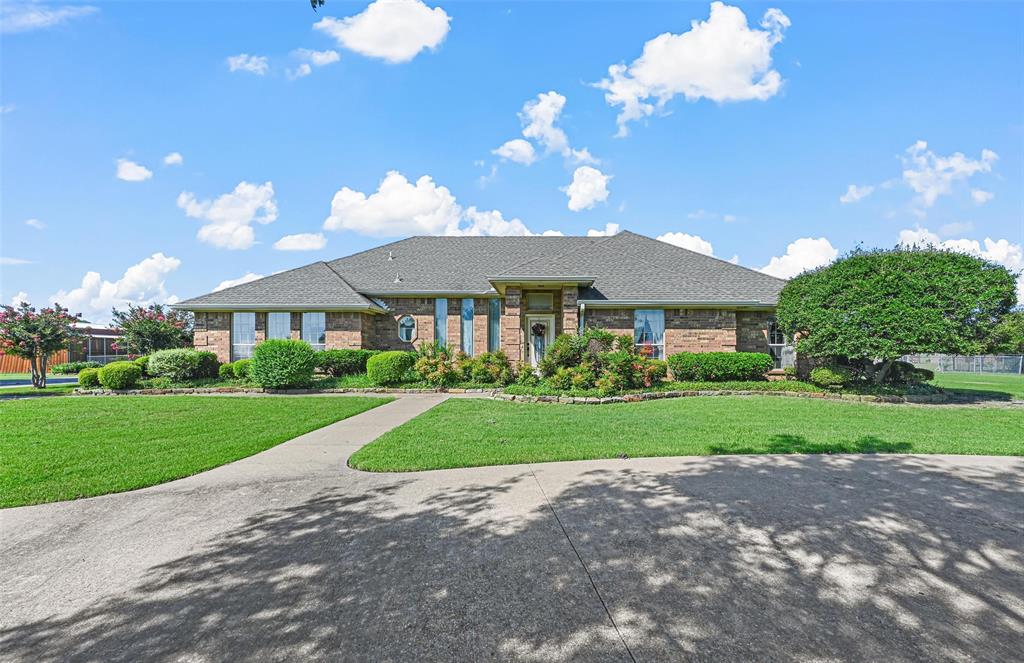 a front view of a house with yard and green space