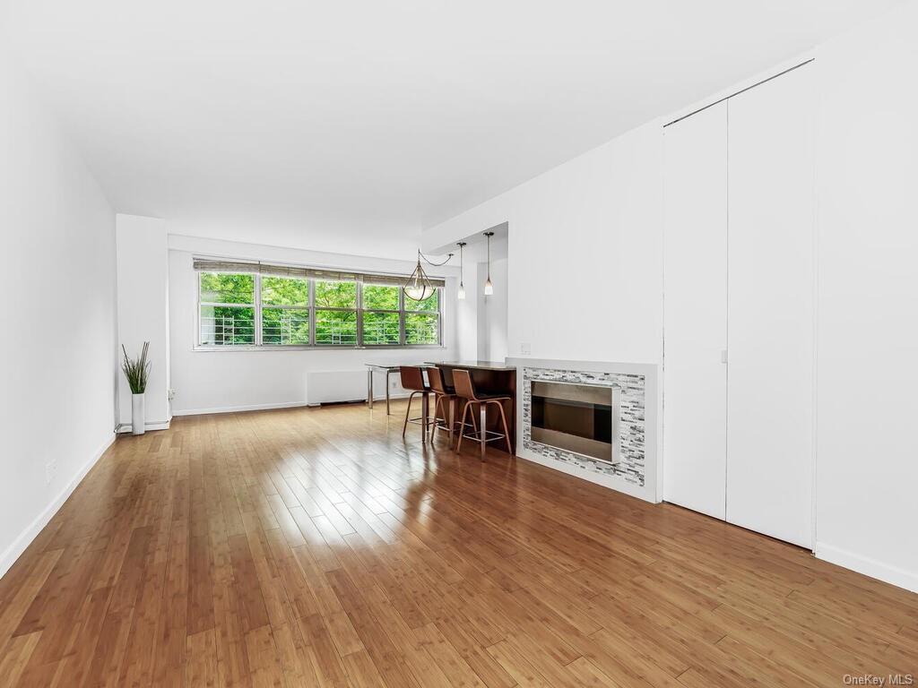 Unfurnished living room featuring hardwood / wood-style floors and a chandelier