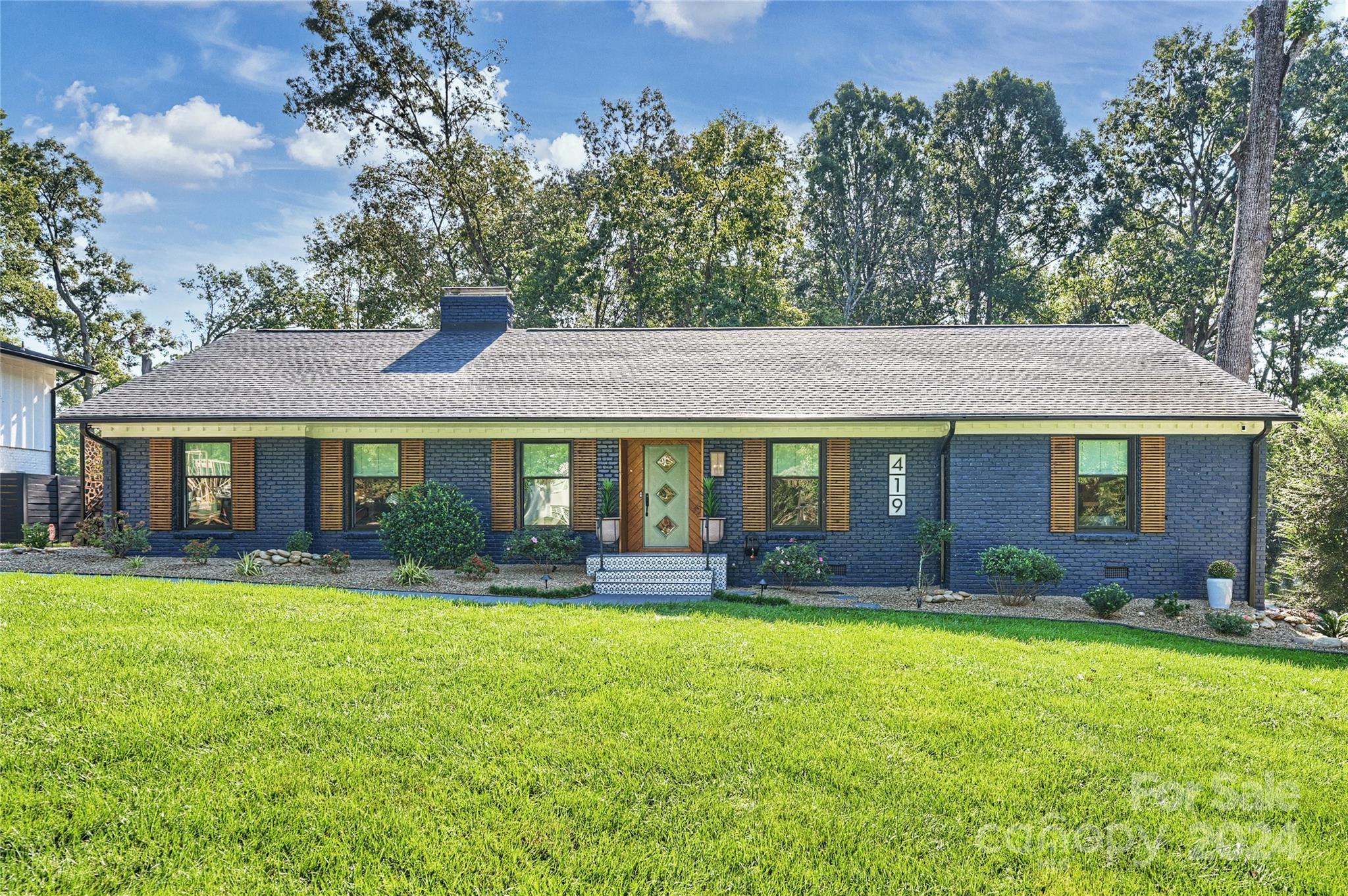 a front view of a house with a yard and trees