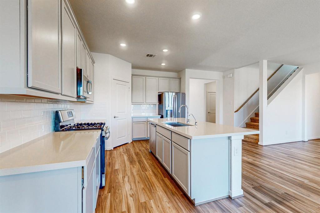 a kitchen with white cabinets and stainless steel appliances