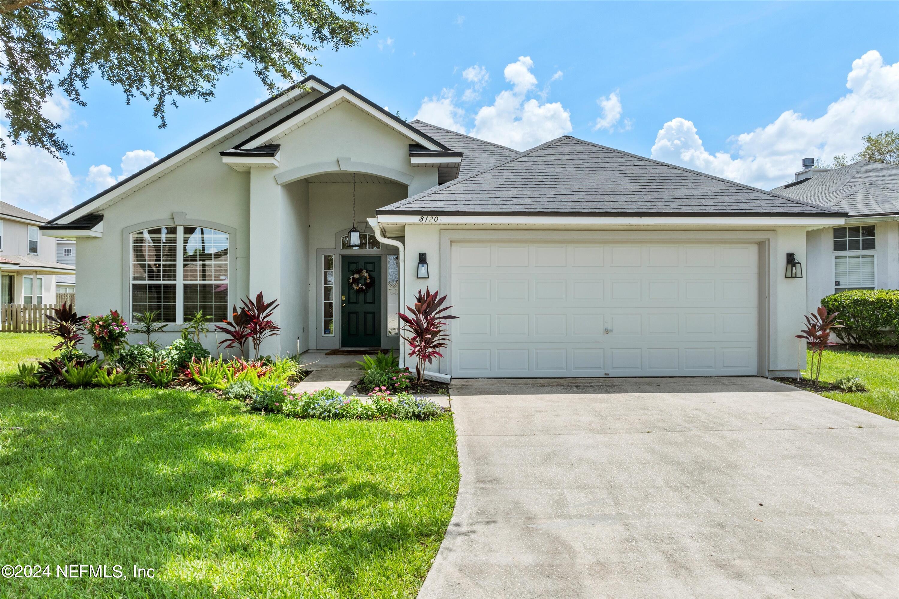 a front view of a house with a yard and garage