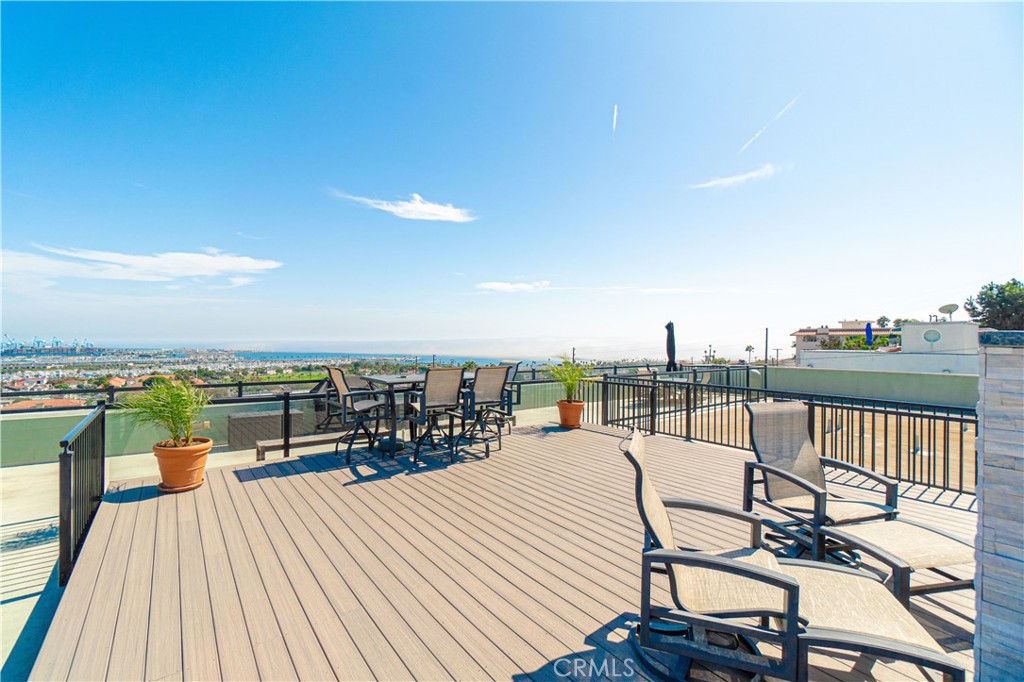 a view of a roof deck with couches and wooden floor