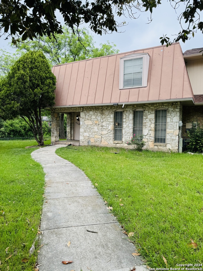 a view of a house with a swimming pool and a yard