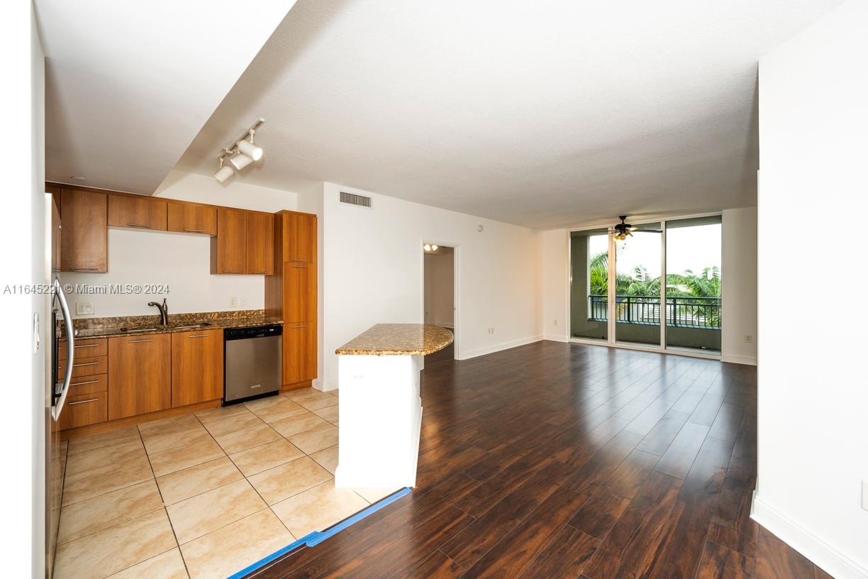 a kitchen with granite countertop a stove and a wooden floors