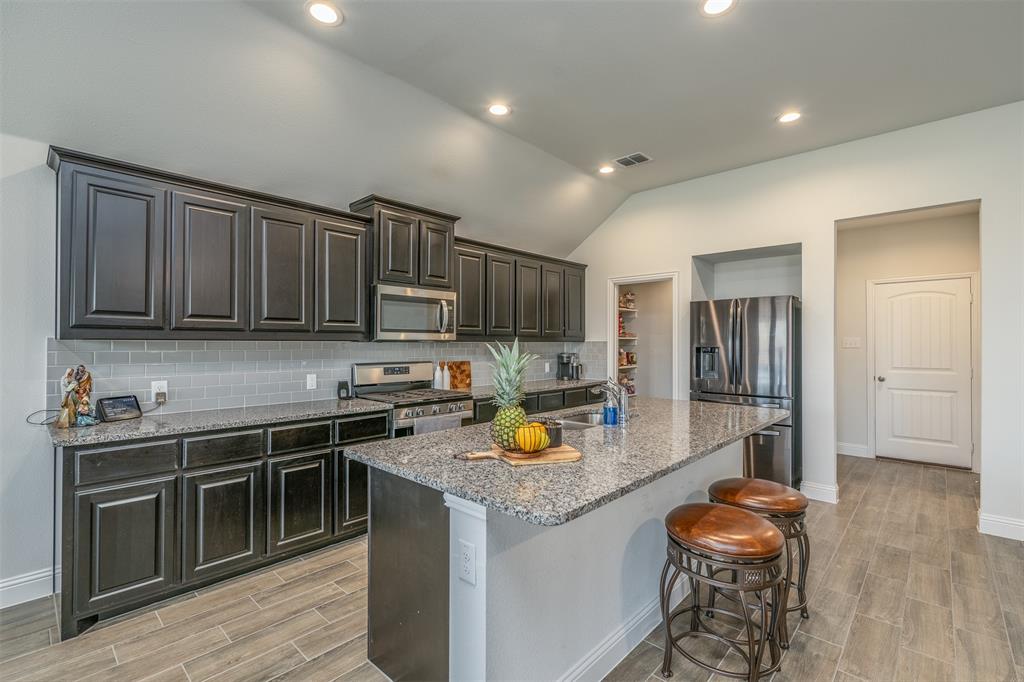 a kitchen with stainless steel appliances granite countertop a stove sink and cabinets