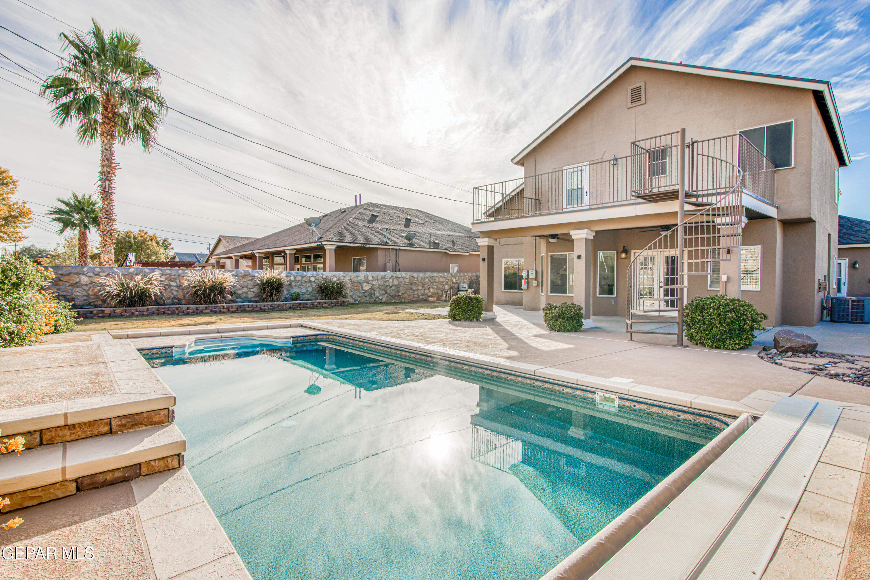 a view of a house with pool lawn chairs and couches chairs