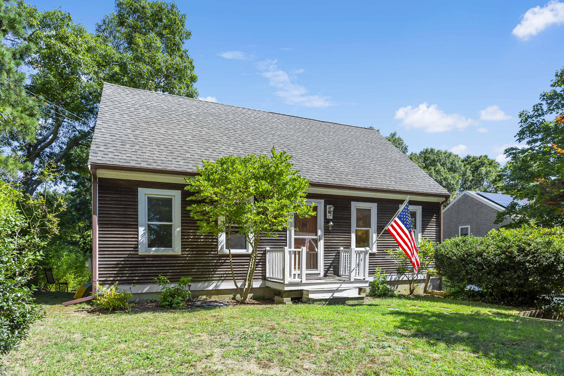 a front view of a house with a yard and potted plants