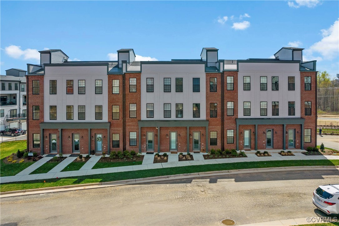 a front view of a residential apartment building with a yard