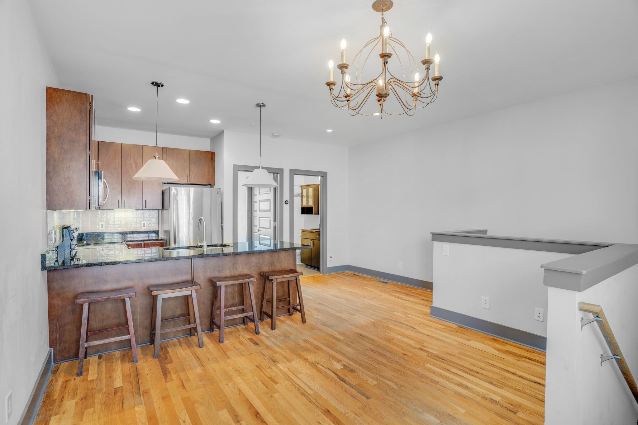 a dining room with wooden floor a chandelier a wooden table and chairs