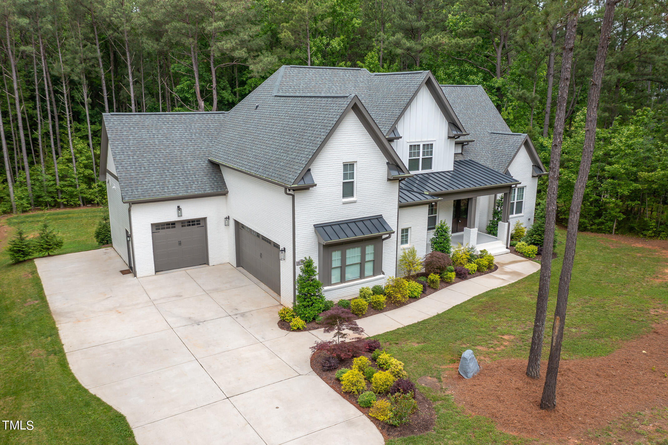 a aerial view of a house with a yard table and chairs