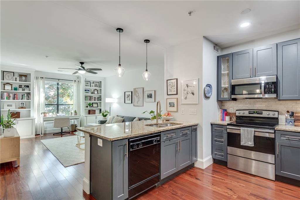 a kitchen with stainless steel appliances granite countertop a sink stove and wooden floor