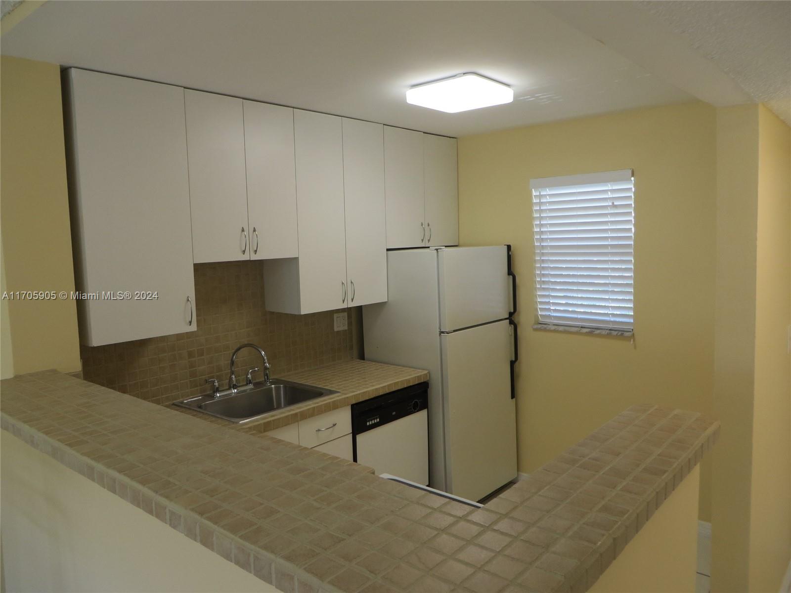 a kitchen with a sink and a refrigerator