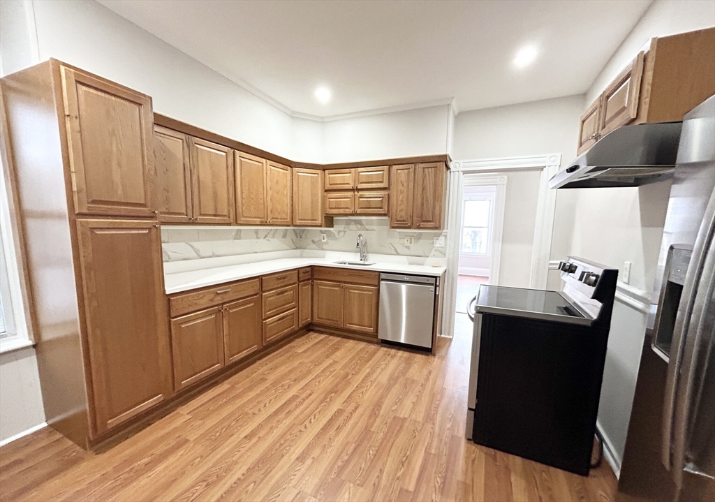 a kitchen with a sink a refrigerator a microwave a sink and cabinets