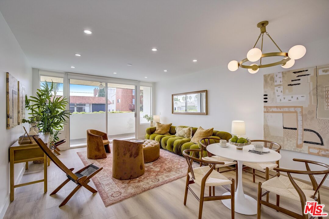 a view of a dining room with furniture a chandelier and wooden floor