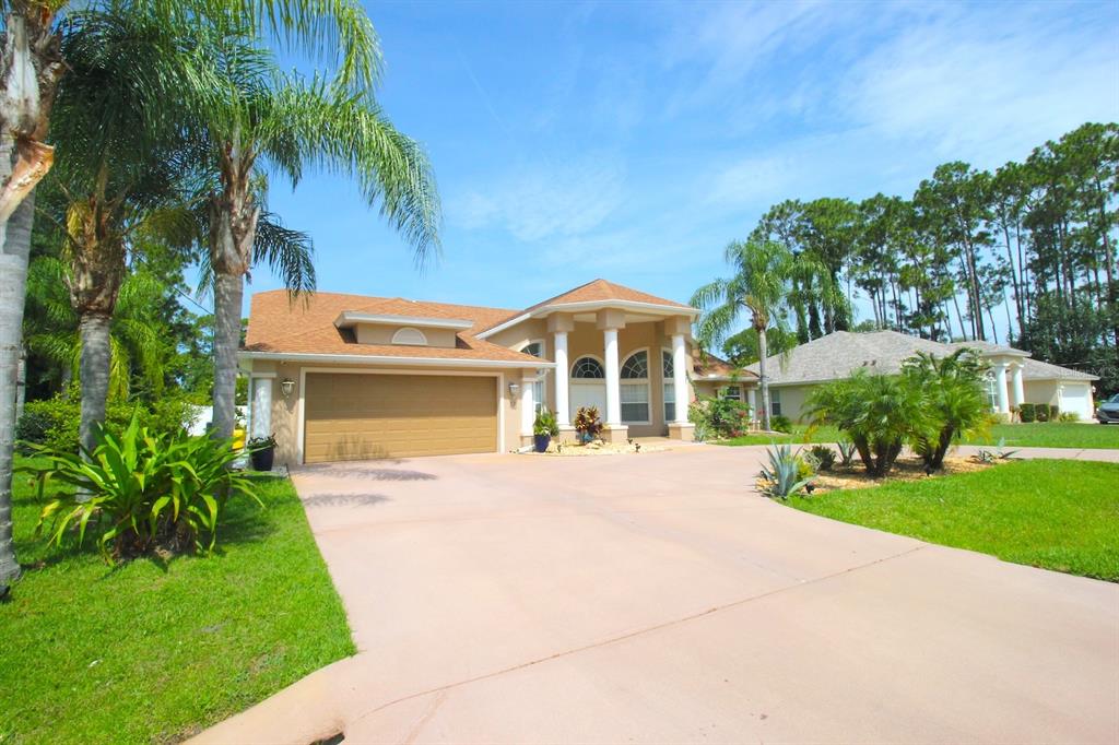 a front view of a house with a garden and yard