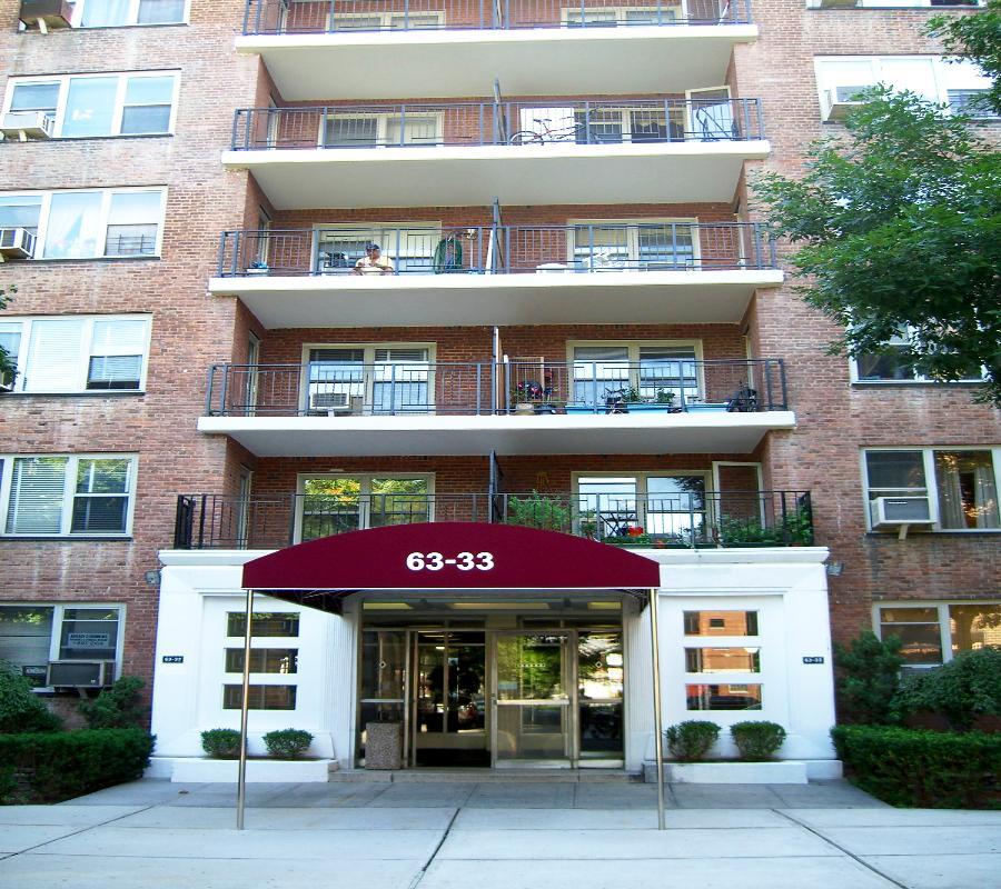 a front view of multi story residential apartment building with a yard