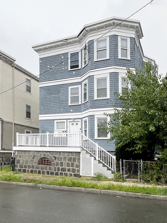 a front view of a house with a garden and plants