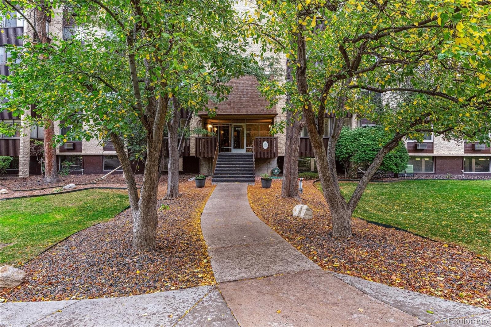 a front view of a house with a yard and garden