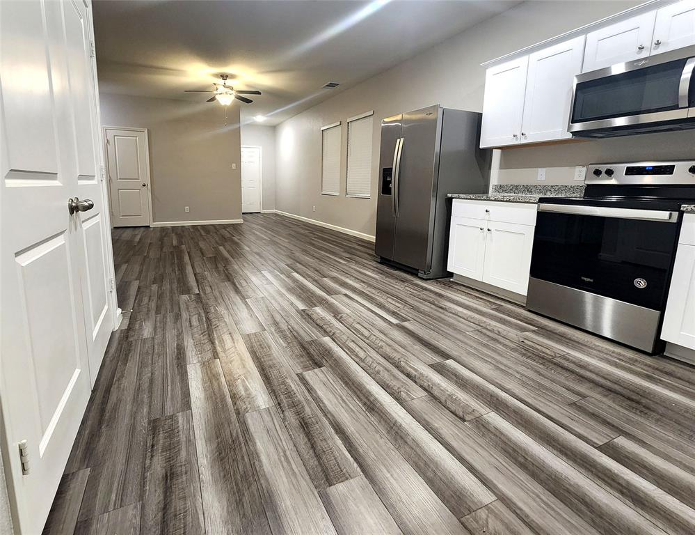 a kitchen with stainless steel appliances granite countertop a refrigerator and a stove top oven