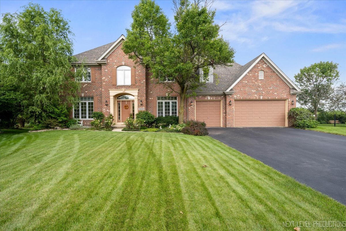 a front view of a house with yard and green space