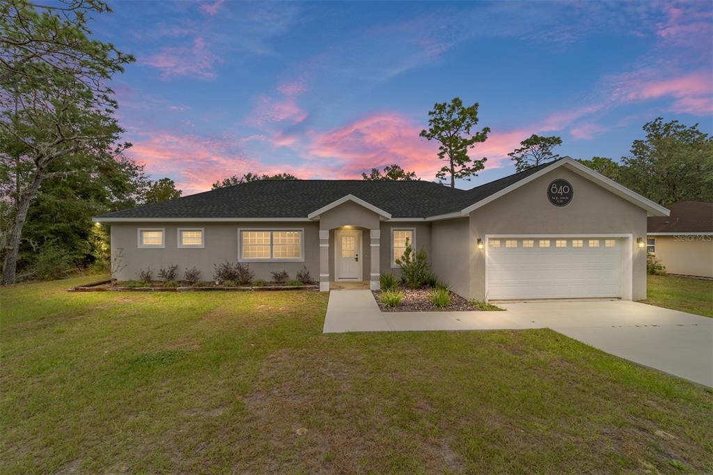 a front view of a house with a yard and garage