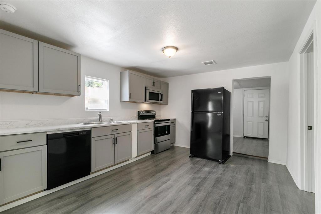 a kitchen with a refrigerator and a stove top oven