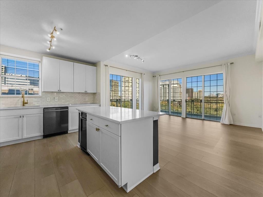 a large kitchen with a large window a sink and stainless steel appliances