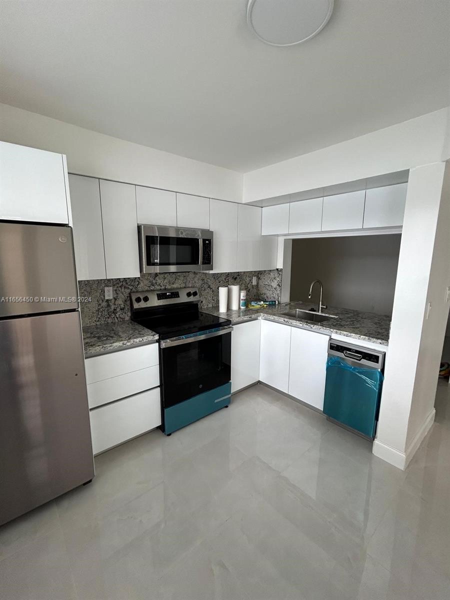 a kitchen with a refrigerator stove and microwave