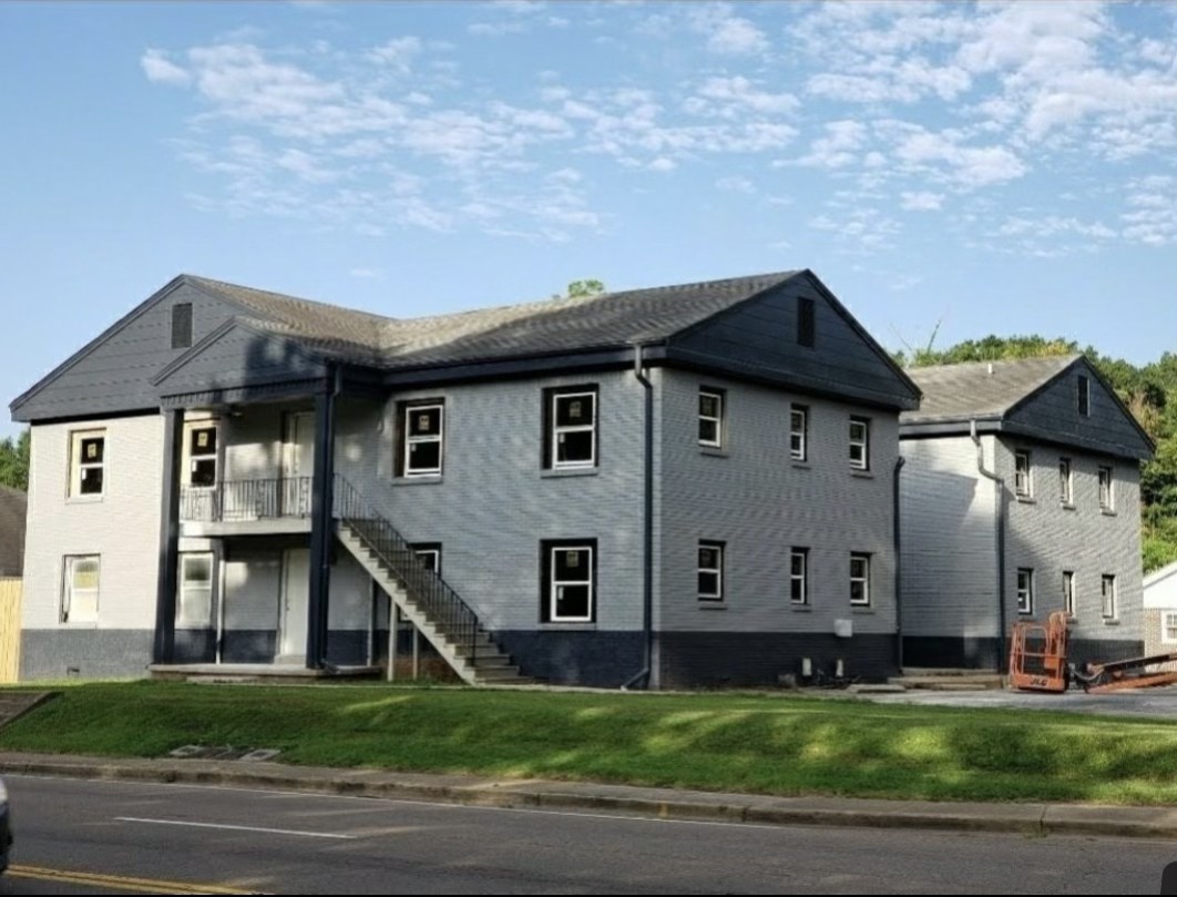 a view of a big house with wooden fence