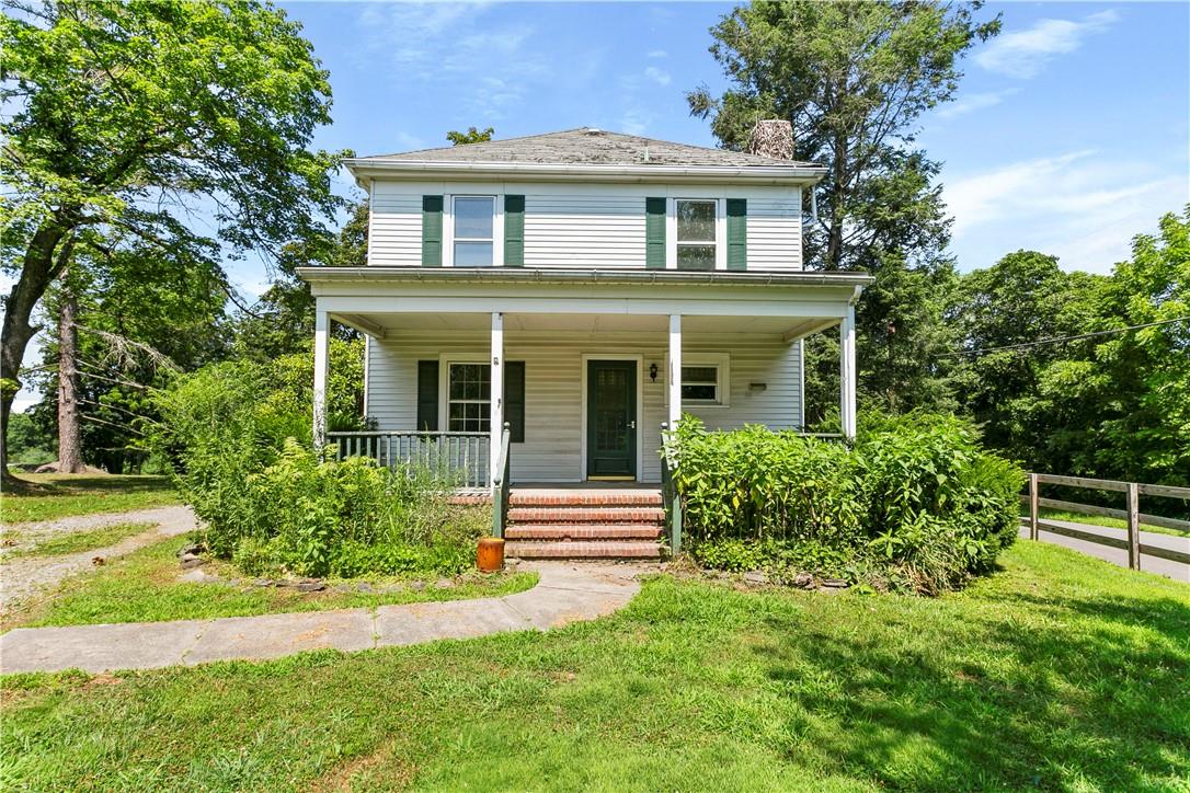 View of front of home featuring covered porch and a front lawn