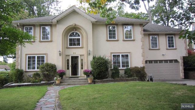 a front view of a house with a garden and plants